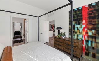 A bedroom with a large bed and a dresser.